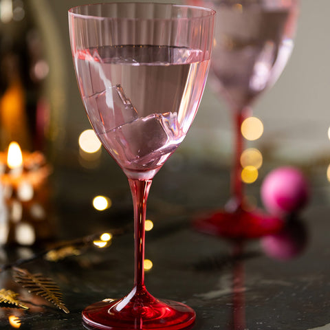 Lifestyle image of the Pink Wine Glass displayed on a table with another in the background, surrounded by candles and fairy lights.