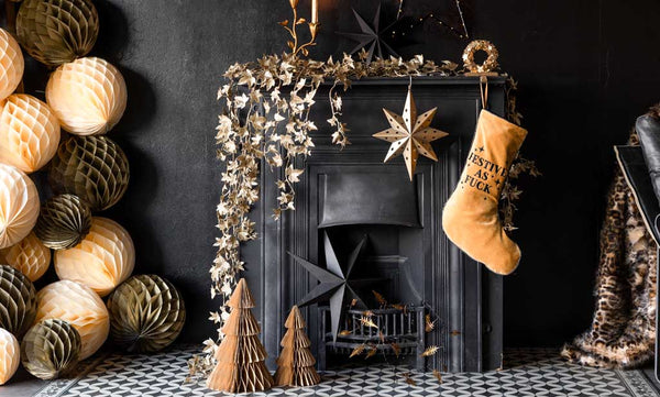 A festive fireplace scene with gold and ivory Christmas decorations.