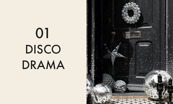 Image of a dark grey front door with a disco ball wreath and silver disco balls.