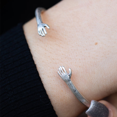 Lifestyle image of the Adjustable Silver Hugs Bangle modelled on a wrist.