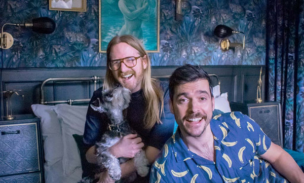 An image of Divine Savages' founders Jamie Watkins and Tom Kennedy at home with their dog