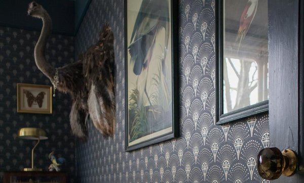 Image of the Divine Savages Deco Martini wallpaper in the home of founders Jamie & Tom with statement artwork and ostrich taxidermy on the wall