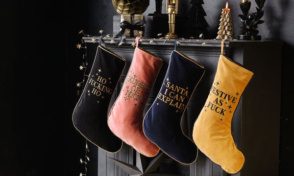 Image of four velvet stockings styled by the fireplace