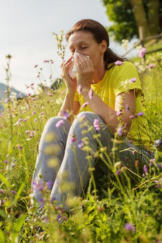 Women experiencing seasonal allergies in a flower field