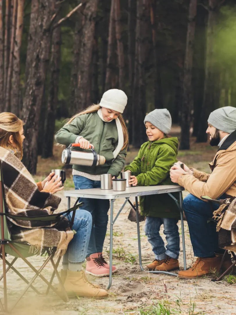 family drinking tea in the woods