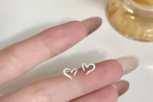 Artisan crafting a unique pair of heartbeat stud earrings.