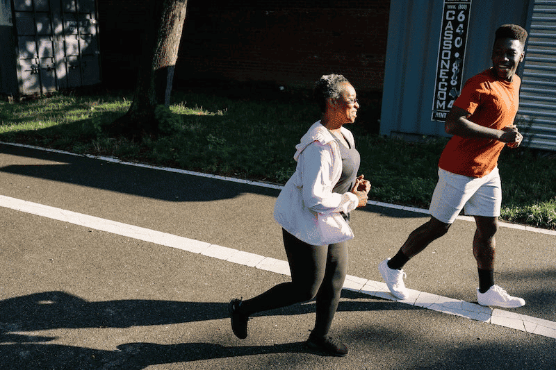 A woman and her son jogging on the street 