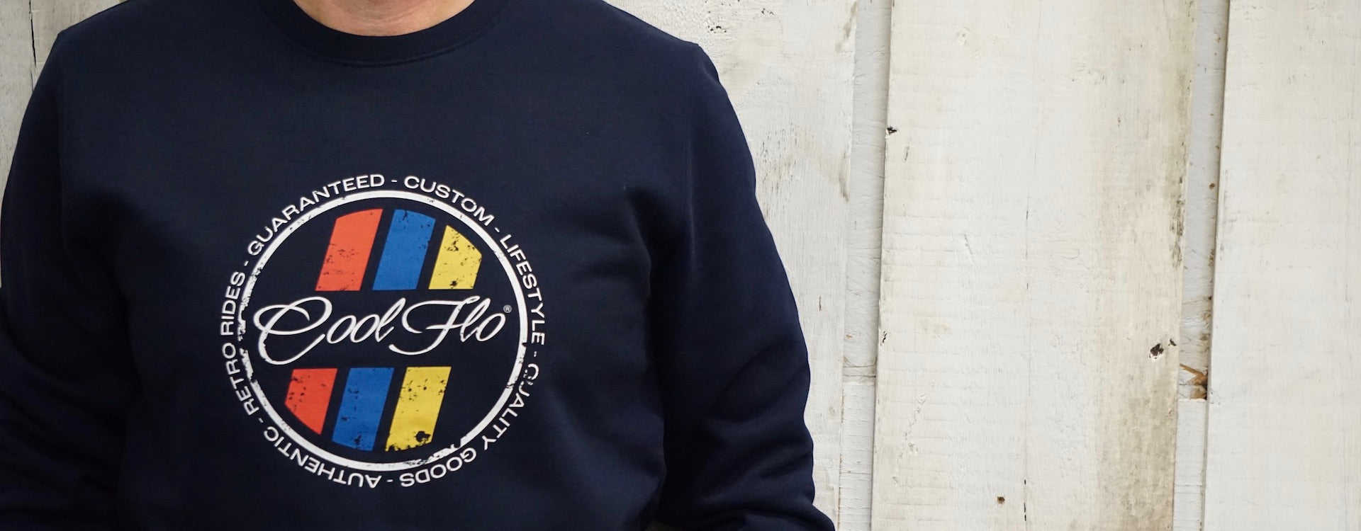 Close-up of navy sweatshirt with circular colourful Retro Stripes design printed on the front..