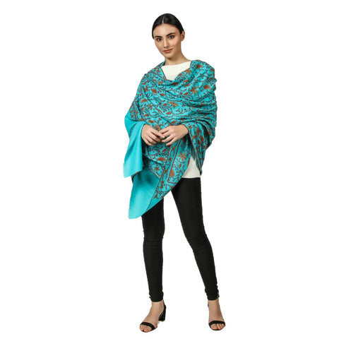a Model wearing a sea green pashmina shawl like a wrap in a classy way the pashmina shawl is embroidered with multi color sozni embroidery