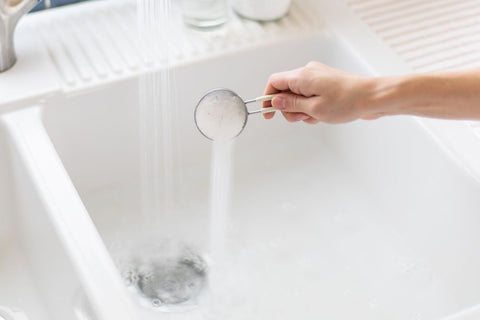 A white color wash basin being pored with water and mild detergent and is being prepared for cleaning of Cashmere scarf