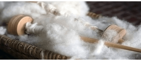 Raw cashmere fibers in a basket with wooden sticks to hold it together