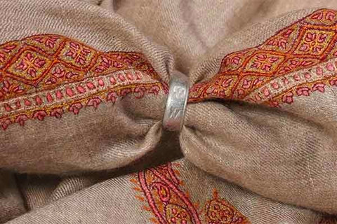 A Shahtoosh shawl in a ring with brown color background and embroidery