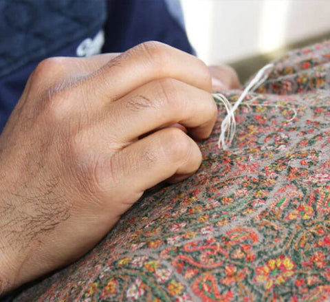 A KASHMIRI artisan doing a Sozni embroidery on a Pashmina shawl with the use of a needle