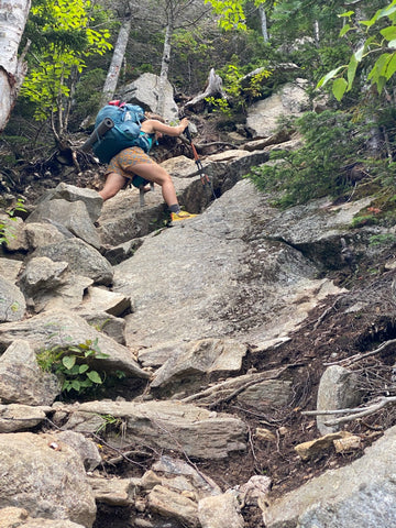 Hiker climbing steep rocks