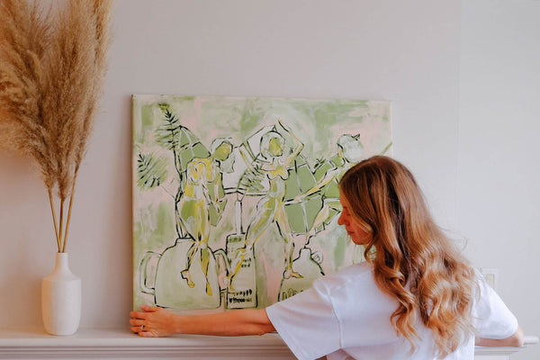 Erin Halla artist with painting on mantle