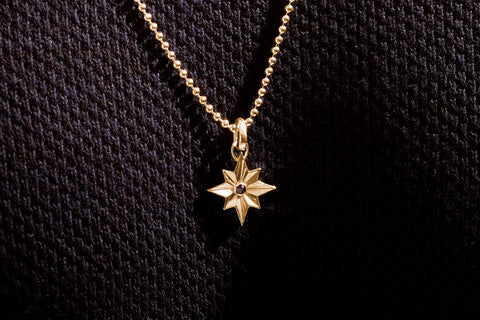 Gold necklace with star pendant and black diamond