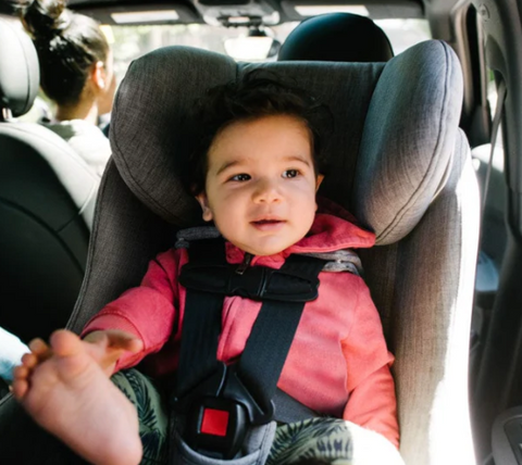 Child sitting in a foonf convertible car seat