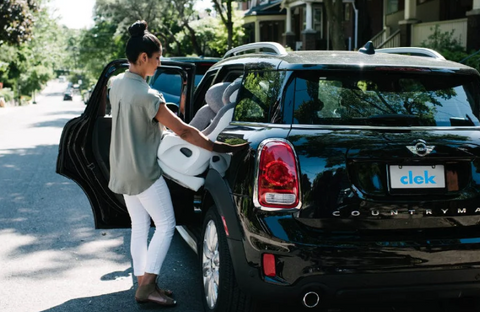 Woman putting Clek car seat into car