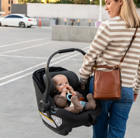 woman holding UppaBaby Aria infant car seat