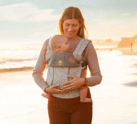 Woman enjoying a walk on the beach with her baby