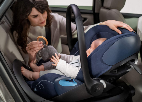 Woman playing with baby in Cybex Cloud G car seat