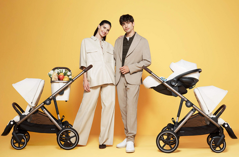 Woman and man standing by cybex gazelle double stroller