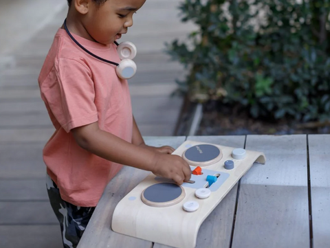 boy playing with plan toys dj mixing board