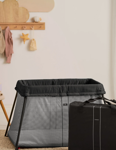 Traveling family setting up travel crib perfect for first trip with baby