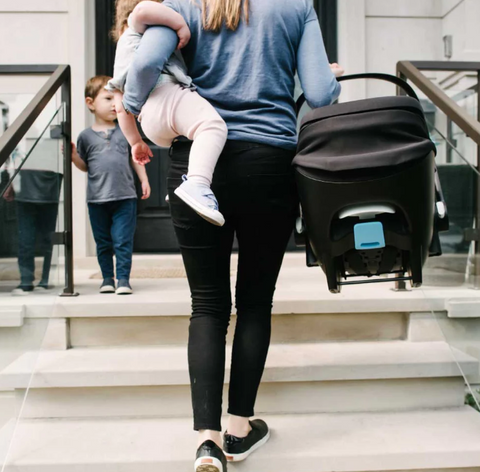 Woman traveling with baby and her infant car seat