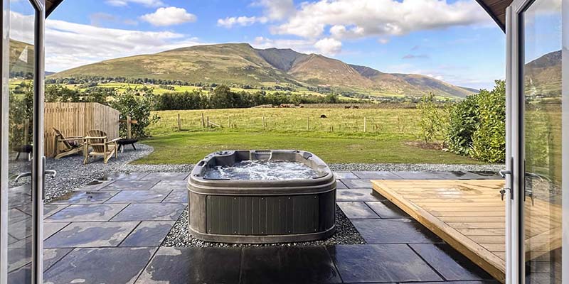 RotoSpa hot tub outdoors with mountain backdrop, wide-angle view.