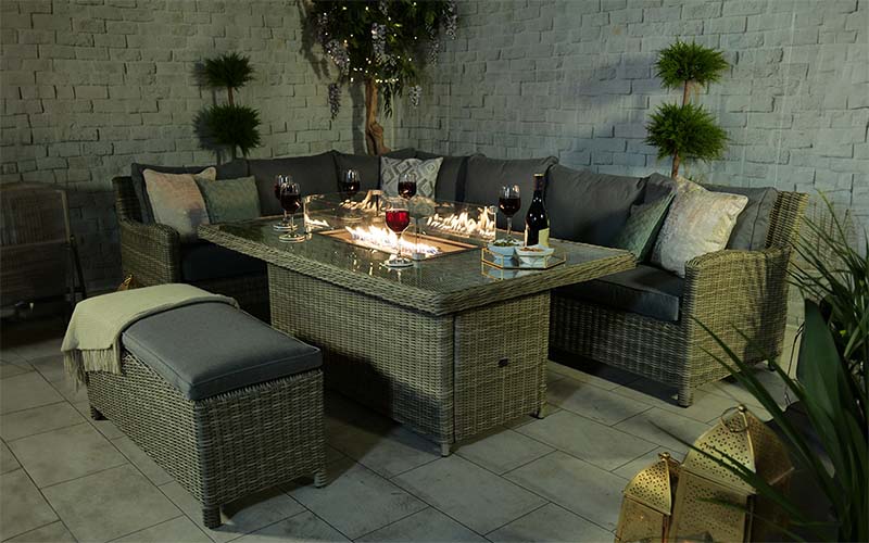 Wentworth Fire Pit Dining & Lounge Set with Rectangular Table, featuring grey cushions and a warm fire pit, perfect for cosy outdoor gatherings.