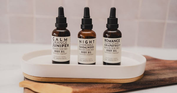 Three bottles of luxuriously nourishing body oil sitting on a tray