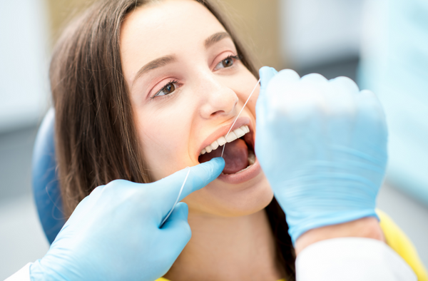 a-lady-getting-dental-floss-by-dentist