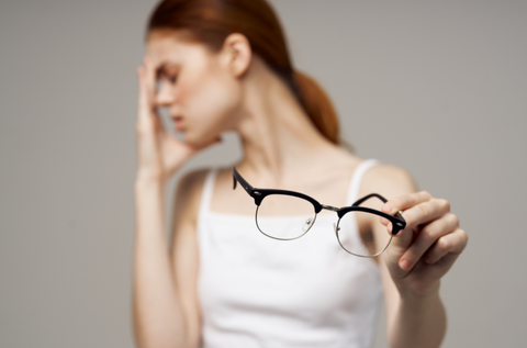 a women with glasses having headache