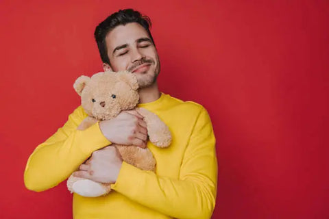 guy smiling and hugging a teddy bear