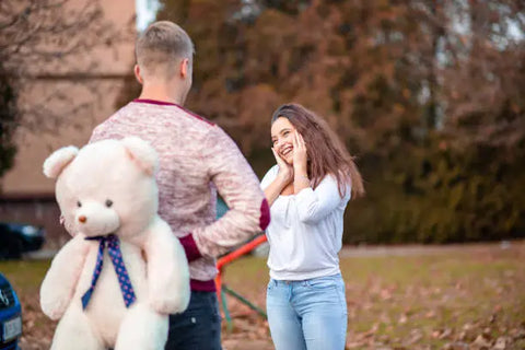 guy surprising girl with teddy bear