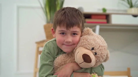 kid hugging teddy bear