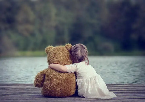 young girl hugging teddy bear