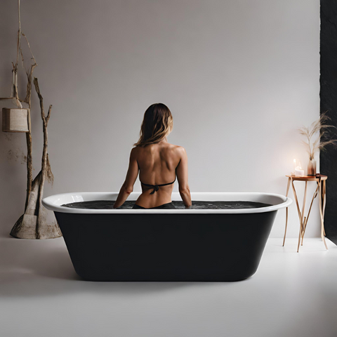 Woman having a cold plunge on a black tub