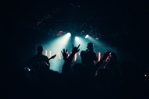 Sihlouettes of Shangrila performing on stage at Amplifier Bar in Perth. A silhouette of a hand making the "devil horns" symbol can be seen emerging from the crowd.