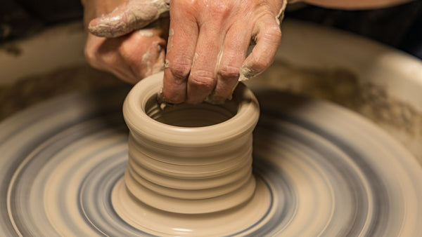 Person creating pottery on a pottery wheel