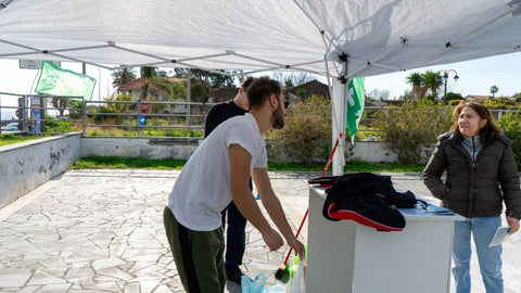 Volontari che distribuiscono le attrezzatura per la raccolta dei rifiuti
