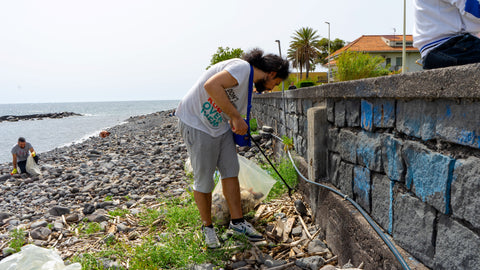 Volontario mentre recupera un rifiuto dalla spiaggia di Riposto durante l'evento del 28-4-2024