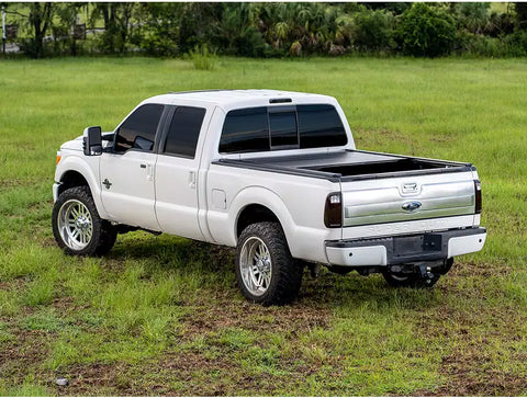 Half open GMC tonneau over on a white trucl