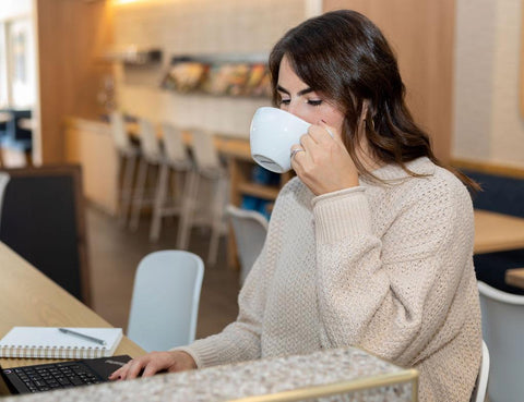 Woman drinking coffee while working.