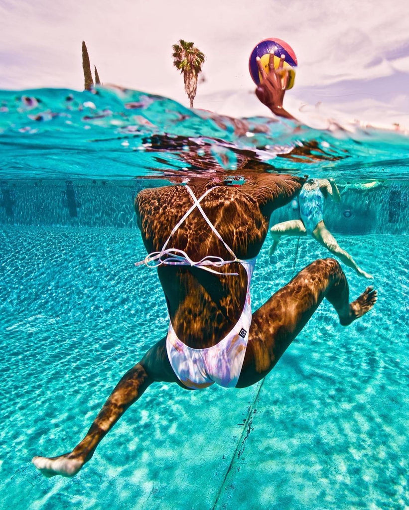 Woman in swimming costume in the pool with a ball in her hand