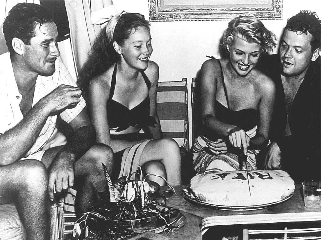 A bordo del yate «Zaca» de Errol Flynn, fondeado frente a Acapulco, México, Rita Hayworth, actriz de cine, celebra su cumpleaños. De izquierda a derecha: Errol Flynn, su esposa Nora Eddington, Rita y su esposo Orson Wells.
