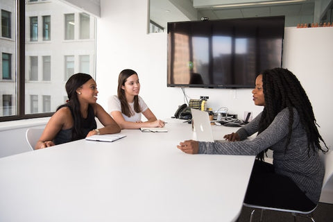 Three women having a discussion in a meeting room