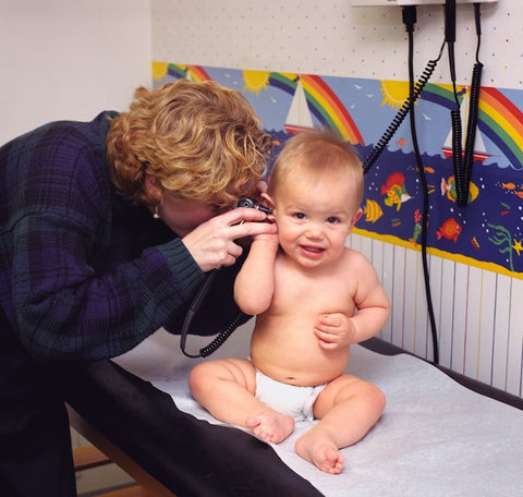 A doctor looking into baby's ear with an instrument