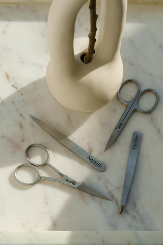 slant tip tweezers, point tip tweezers and scissors on marble slab